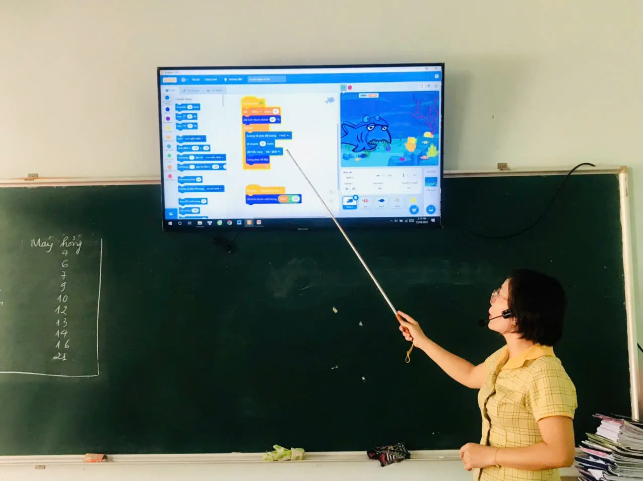 Giáo viên hướng dẫn học sinh lập trình Scratch trong buổi sinh hoạt