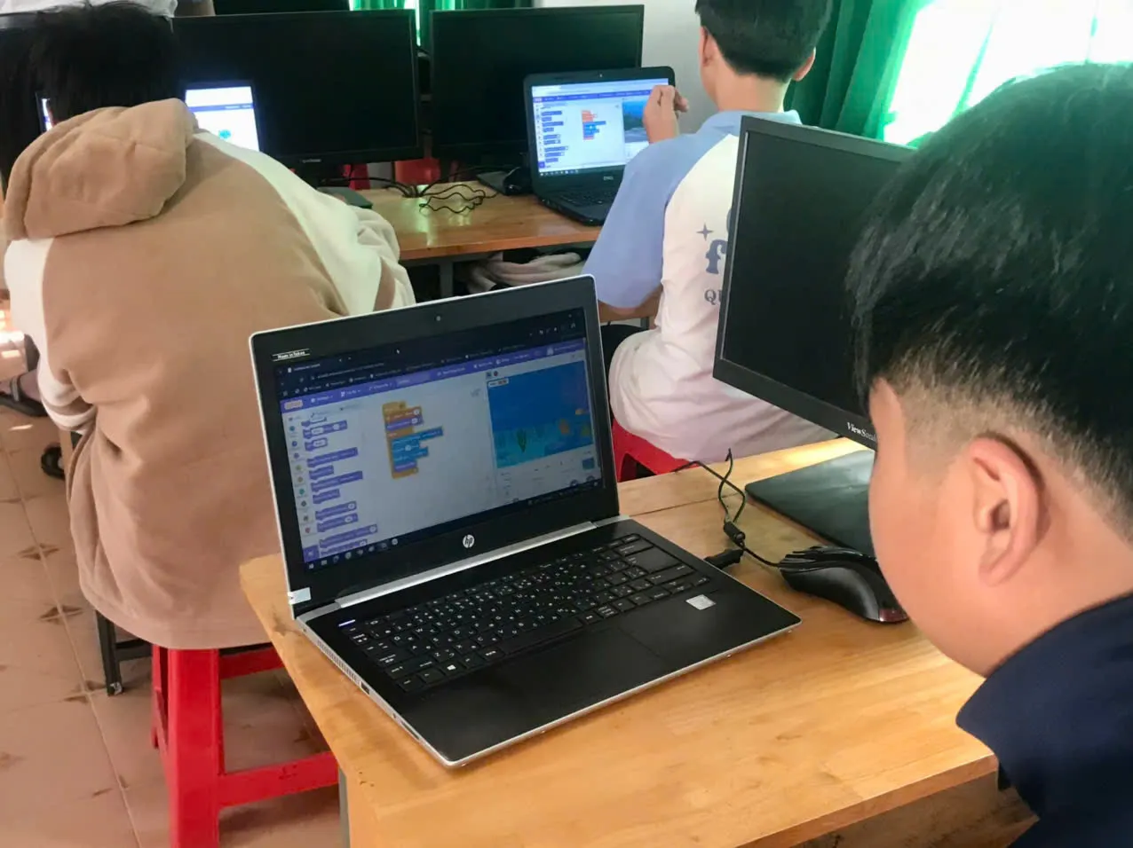 Giáo viên quan sát và hỗ trợ học sinh trong quá trình lập trình